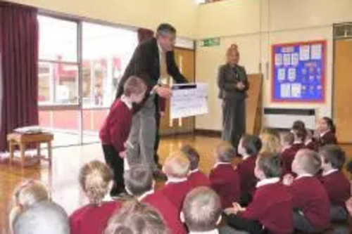 Cllr Brian Gurden presents the cheque to Rucstall pupils